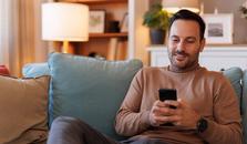 Man sitting on the sofa, surfing on his mobile phone. picture.