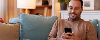 Man sitting on the sofa, surfing on his mobile phone. picture.