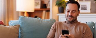 Man sitting on the sofa, surfing on his mobile phone. picture.