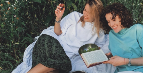 Vänner som halvligger på en filt i gräset