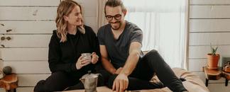 Par spiser frokost i sengen. De smiler. bilde.