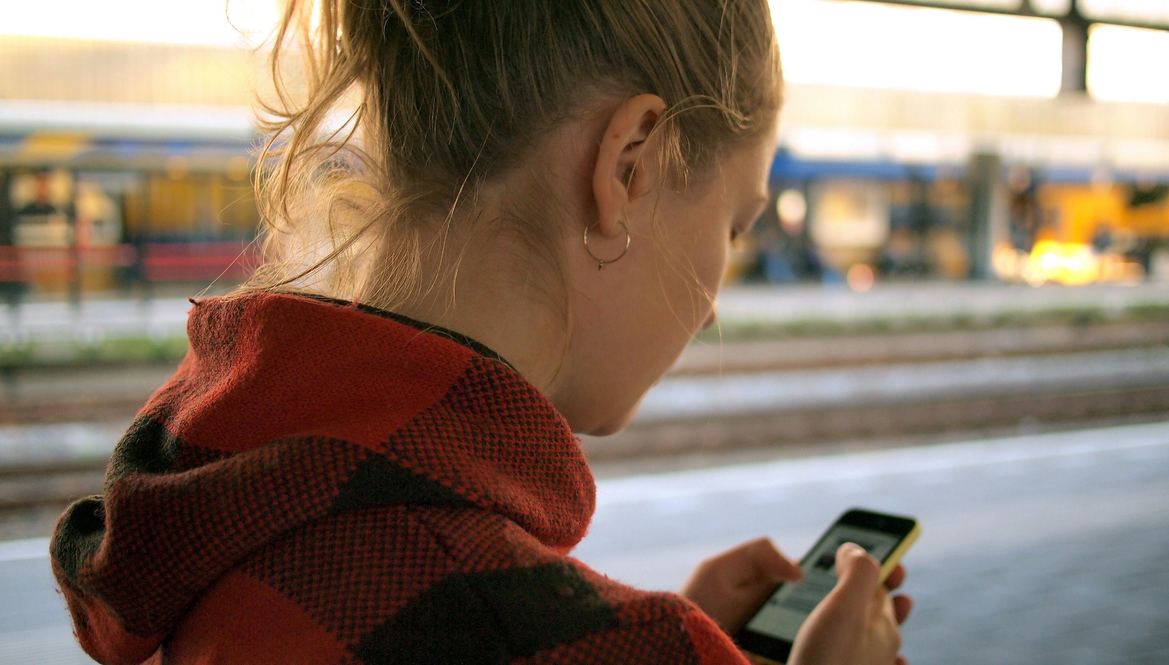 Girl on a train station with smartphone. picture