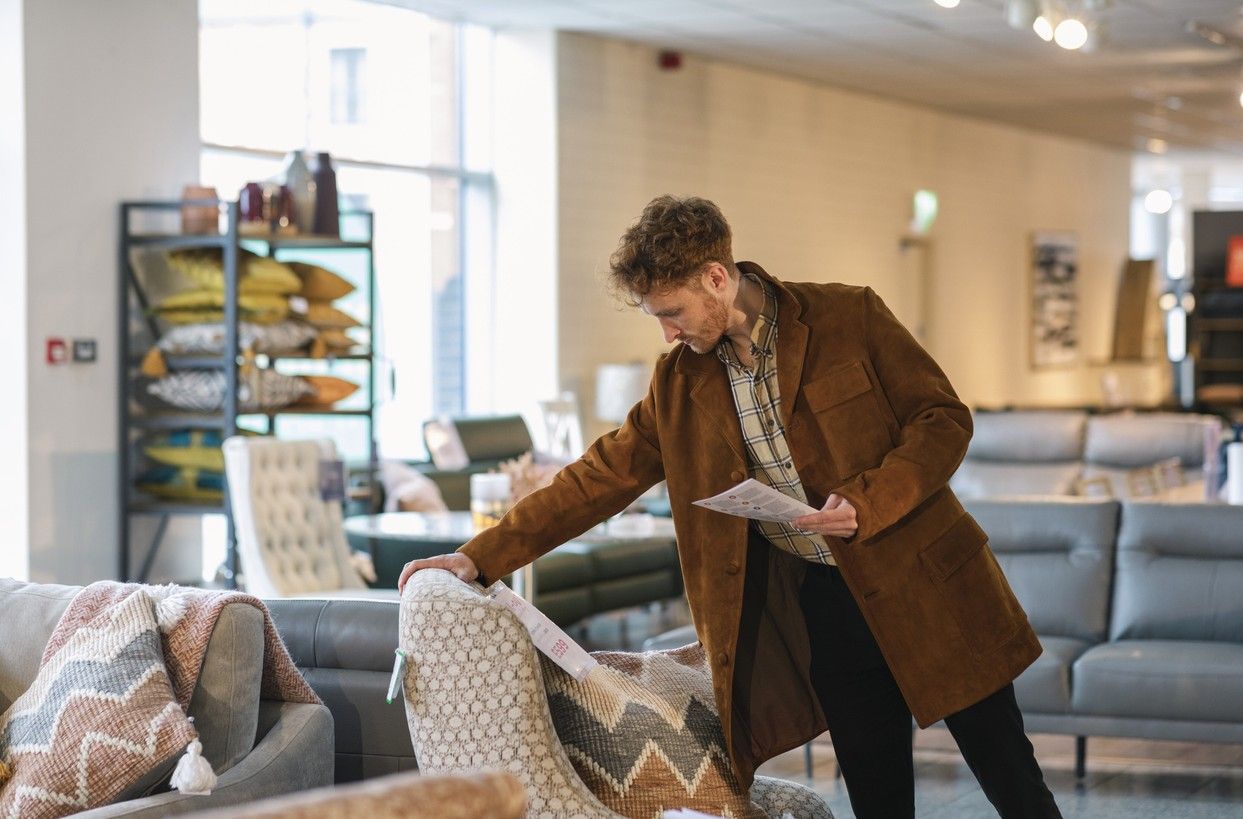 Man skal kjøpe sofa. Han vurderer utsatt betaling. bilde.