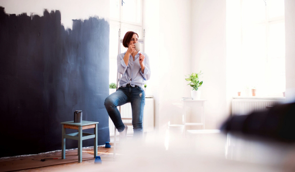 Dame tar en pause i oppussingen og drikker kaffe. bilde.