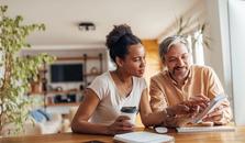 Mann og kvinne sitter ved kjøkkenbordet og lager budsjett. bilde.