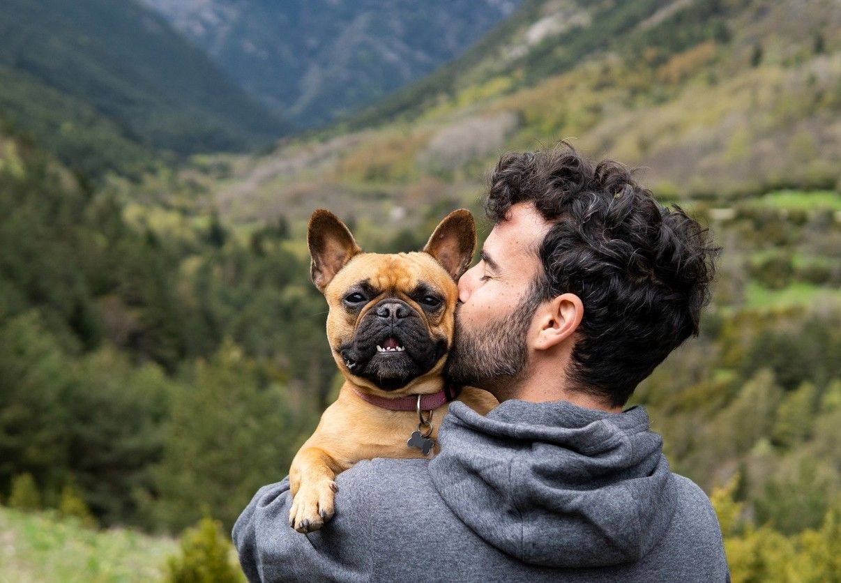 Man med hund ute i naturen. foto.