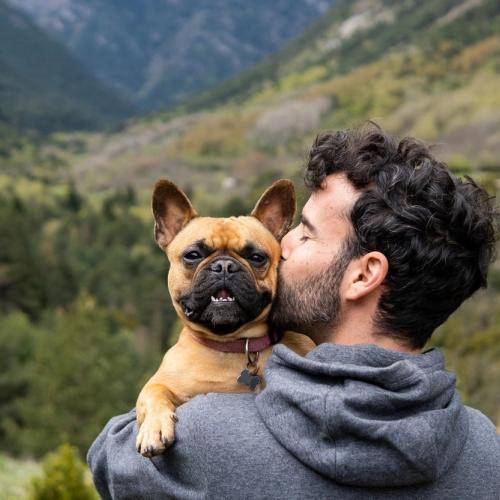 Man med hund ute i naturen. foto.