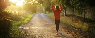 Nainen varhaisella aamulenkillä pienellä tiellä. Valokuva.