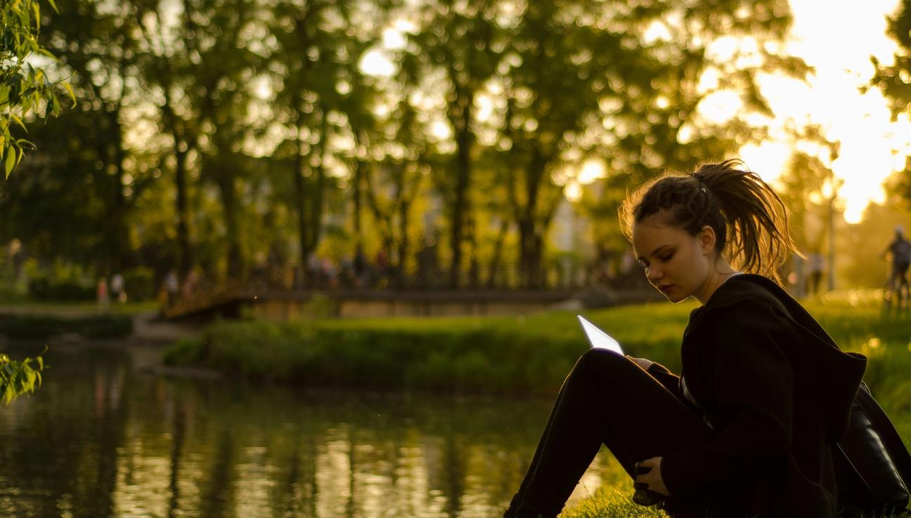 Tyttö istuu veden äärellä