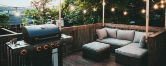 Terrasse klar for sommerfest, med grill og stemningsfull belysning. bilde.