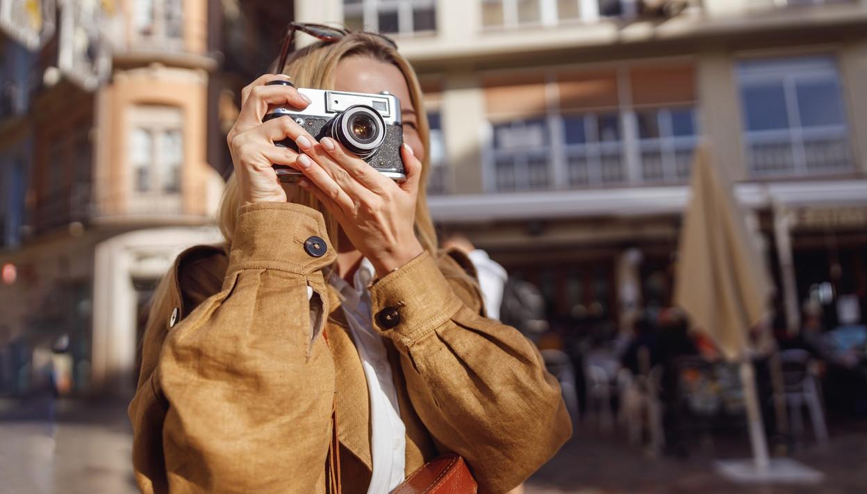 Nainen lomalla ottamassa kuvaa matkallaan. Kuva.