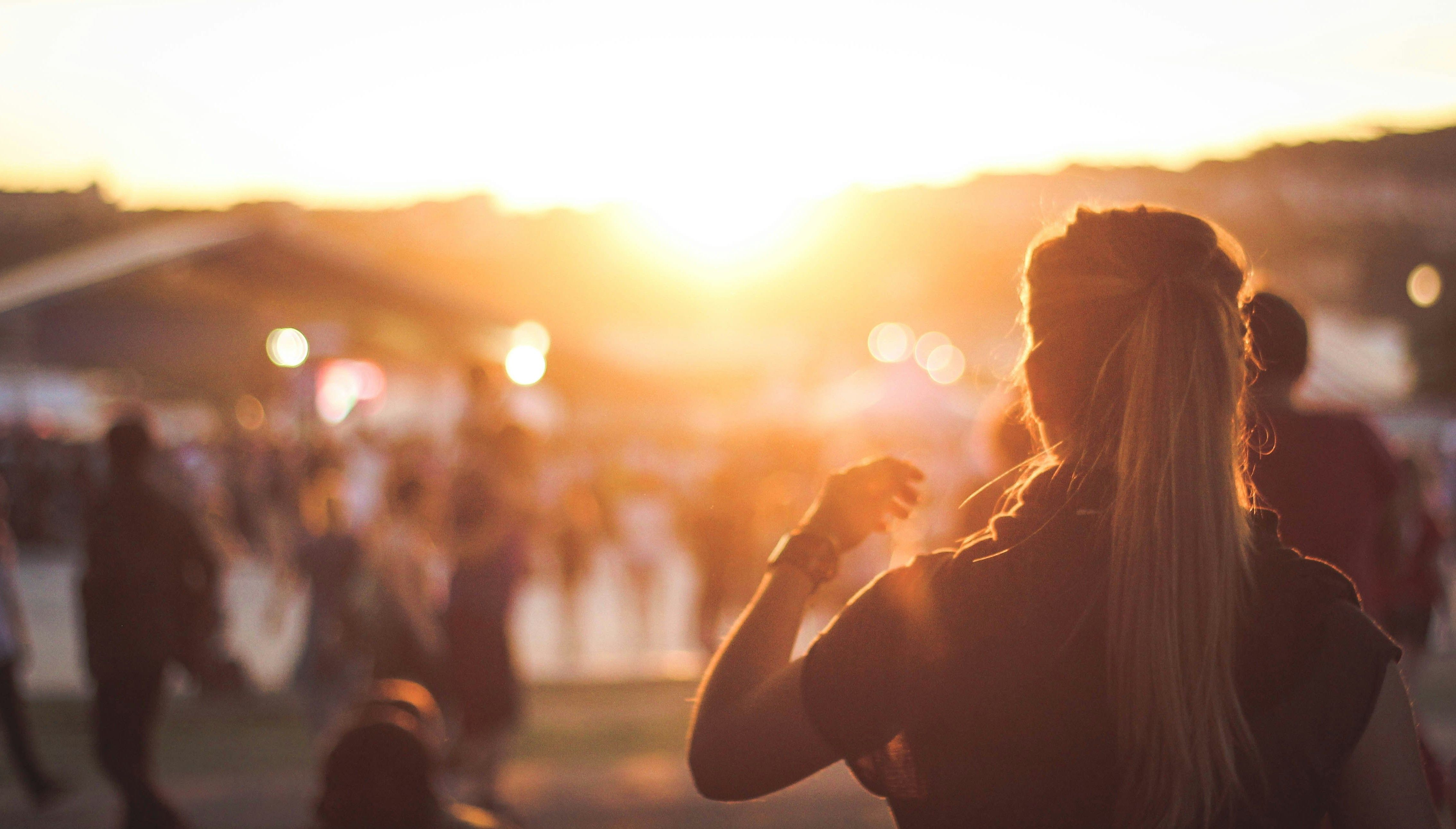 Auringonlasku festivaaleilla. Nainen tanssimassa. Valokuva.