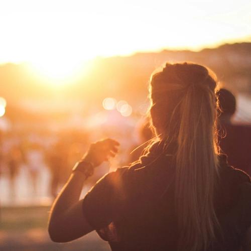 Auringonlasku festivaaleilla. Nainen tanssimassa. Valokuva.