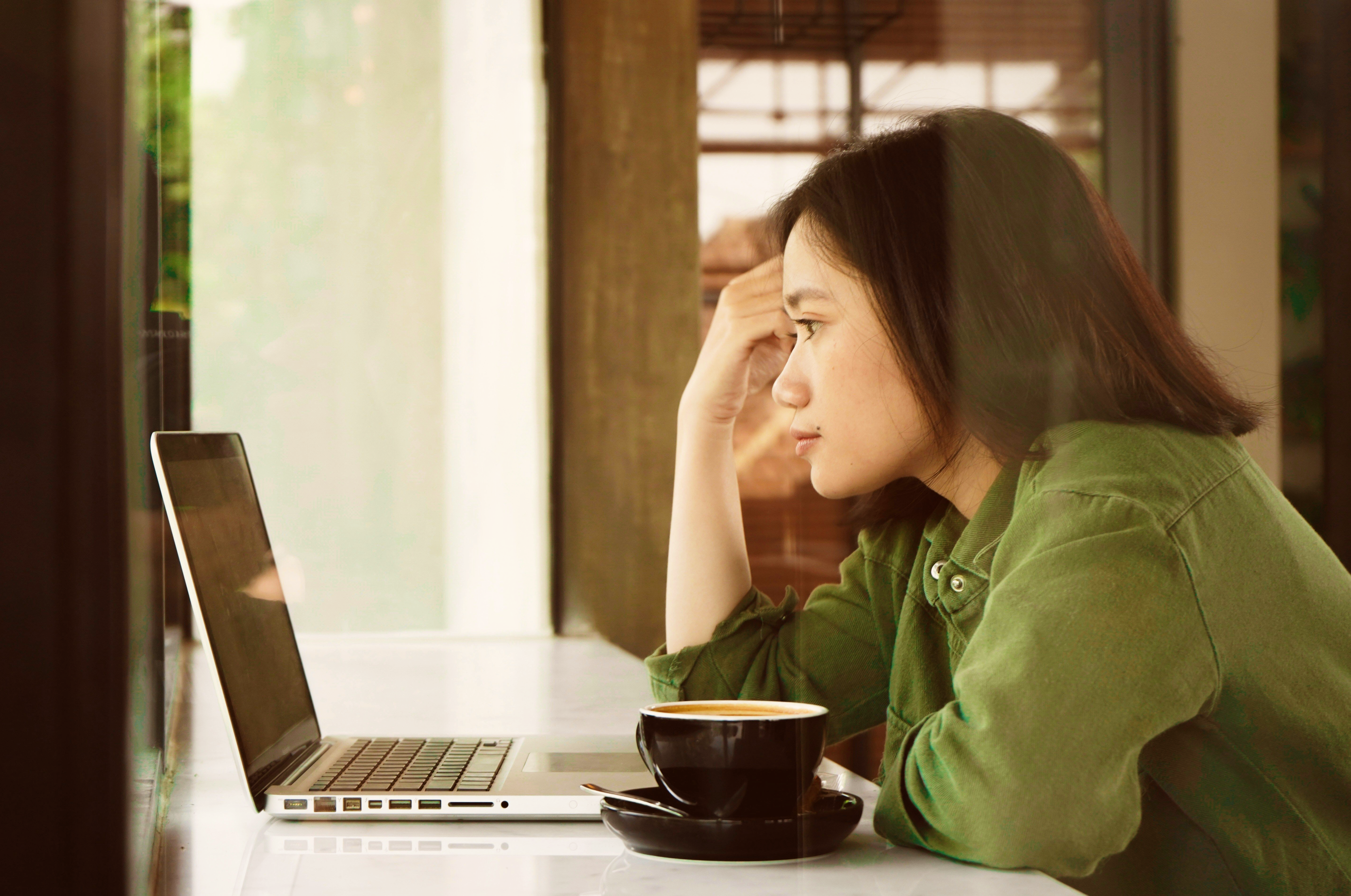 A girl looking at her laptop, reading information on her ID theft protection service. picture.