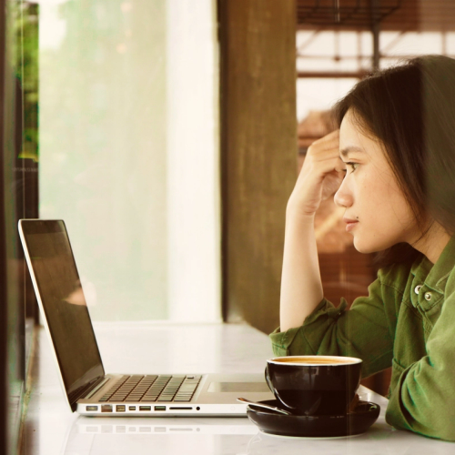 A girl looking at her laptop, reading information on her ID theft protection service. picture.