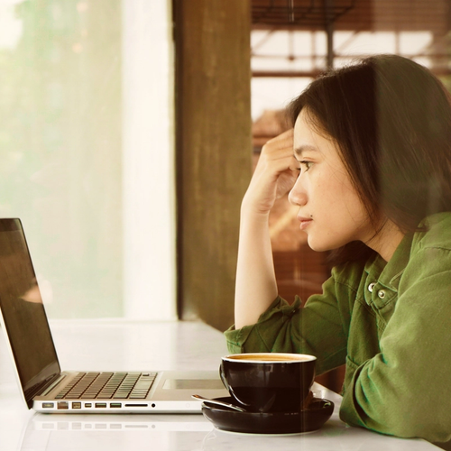 A girl looking at her laptop, reading information on her ID theft protection service. picture.
