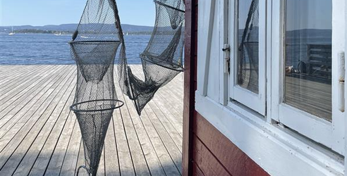 Sjöbod med fiskenät