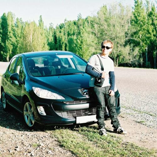 A guy leaning against his car, waiting for assistance as the car has stopped. picture.