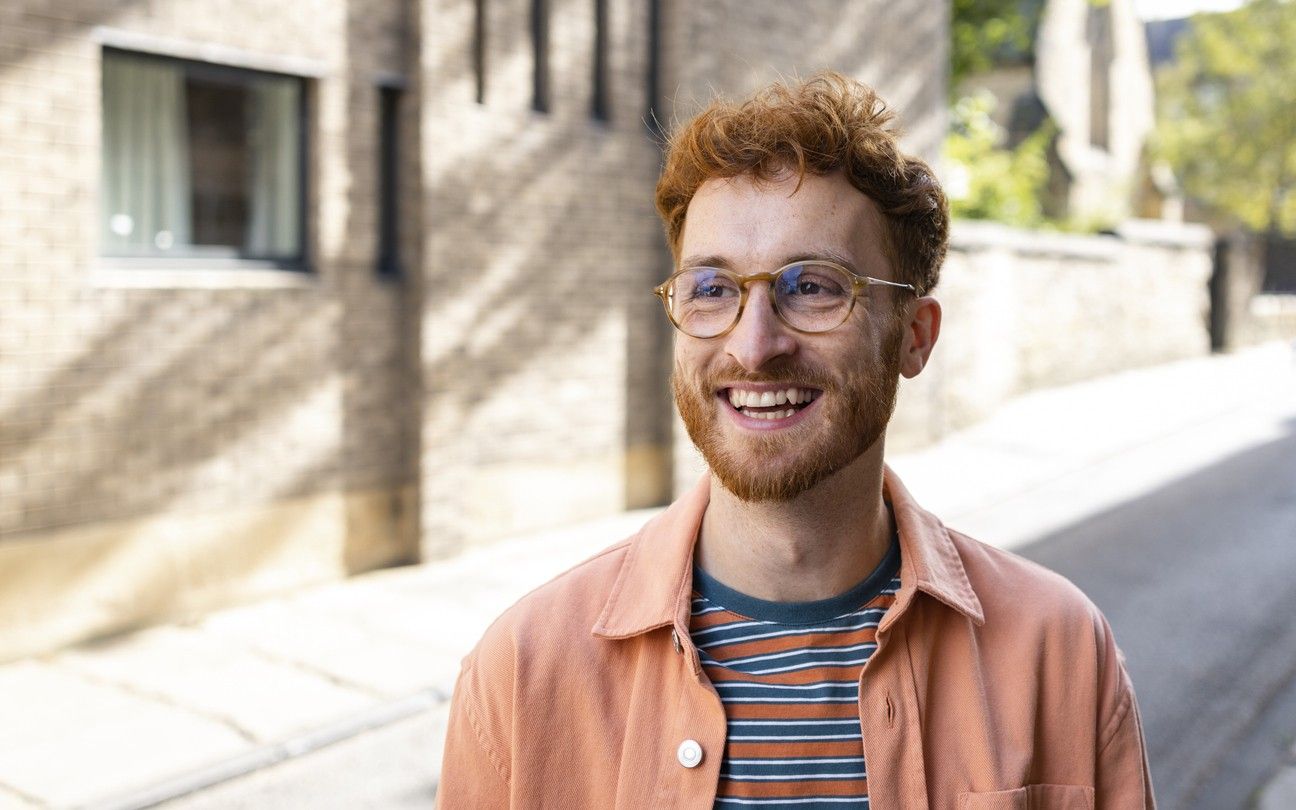 A man with red hair and glasses smiling big. picture.