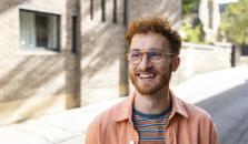 A man with red hair and glasses smiling big. picture.
