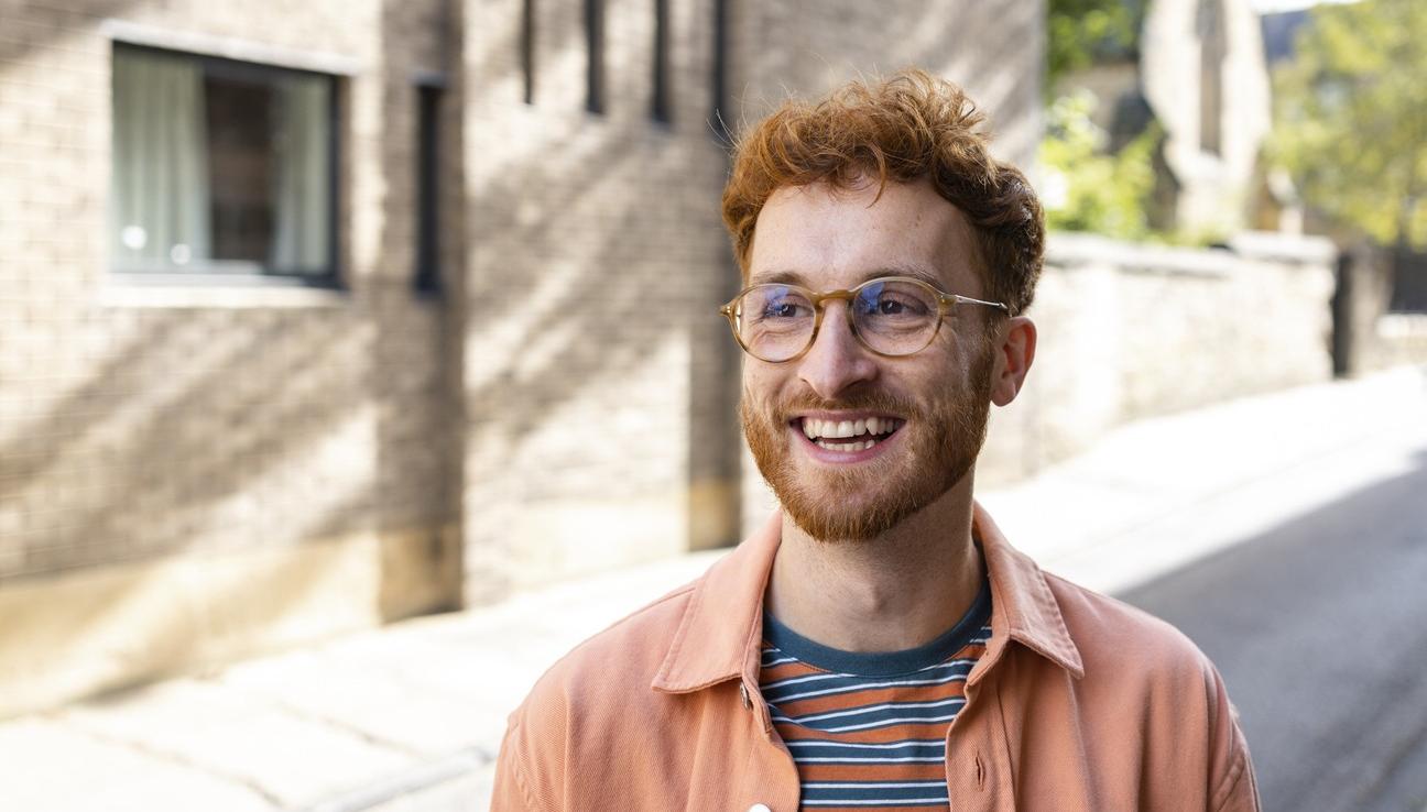 A man with red hair and glasses smiling big. picture.