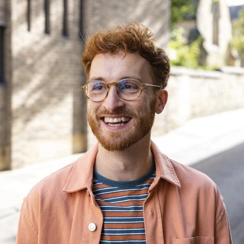 A man with red hair and glasses smiling big. picture.