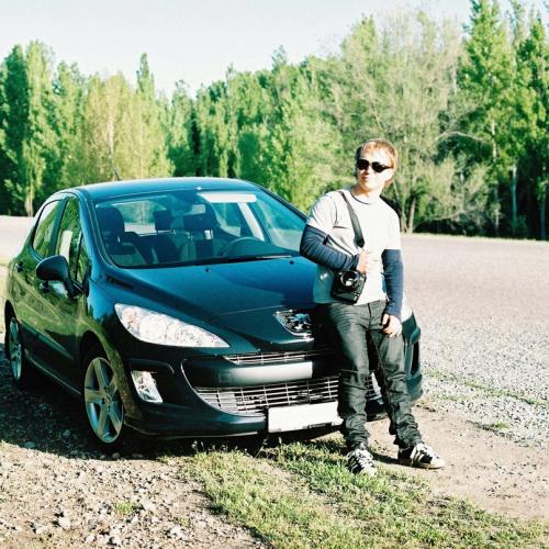 En mann står ved bilen sin og venter. Bilen har fått motorstopp. bilde.