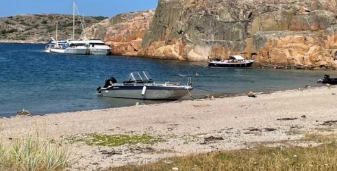 Småbåtar i en vik med sandstrand och klippor på svenska västkusten.