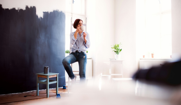 Kvinna tar en paus i renoveringen och njuter av en kaffe