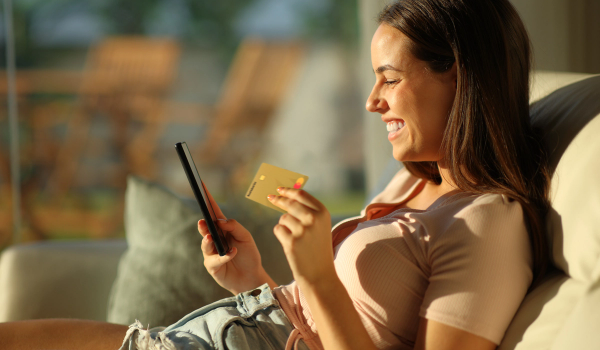 Kvinna med Morrow guldkort och mobiltelefon. foto.