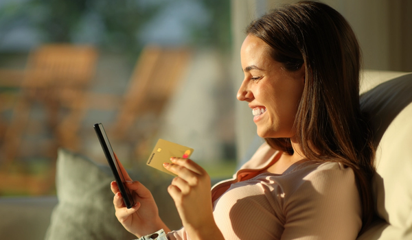 Kvinna med Morrow guldkort och mobiltelefon. foto.