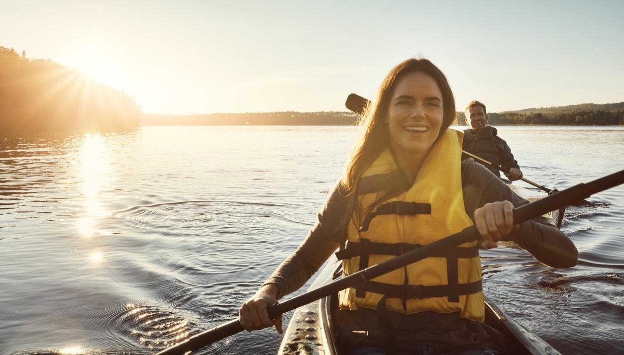 A woman and a man kayaking on a lake. picture.