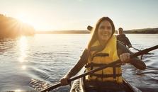 A woman and a man kayaking on a lake. picture.
