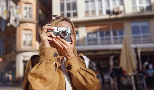 En kvinna på resa tar kort med en vanlig kamera. foto.