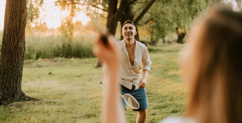 Et par spiller badminton i parken. bilde.