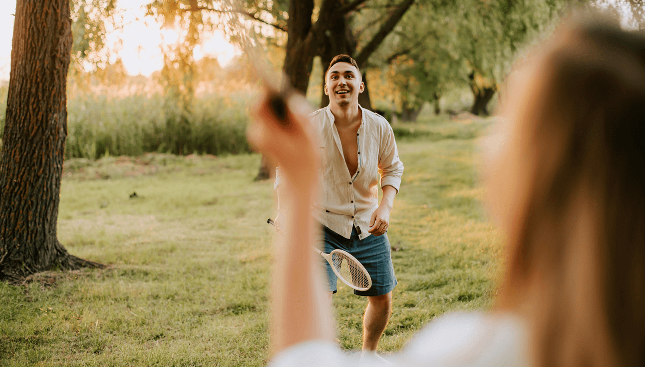Et par spiller badminton i parken. bilde.