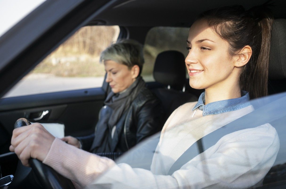 Ung kvinna övningskör med körskolelärare vid sidan av sig. foto.