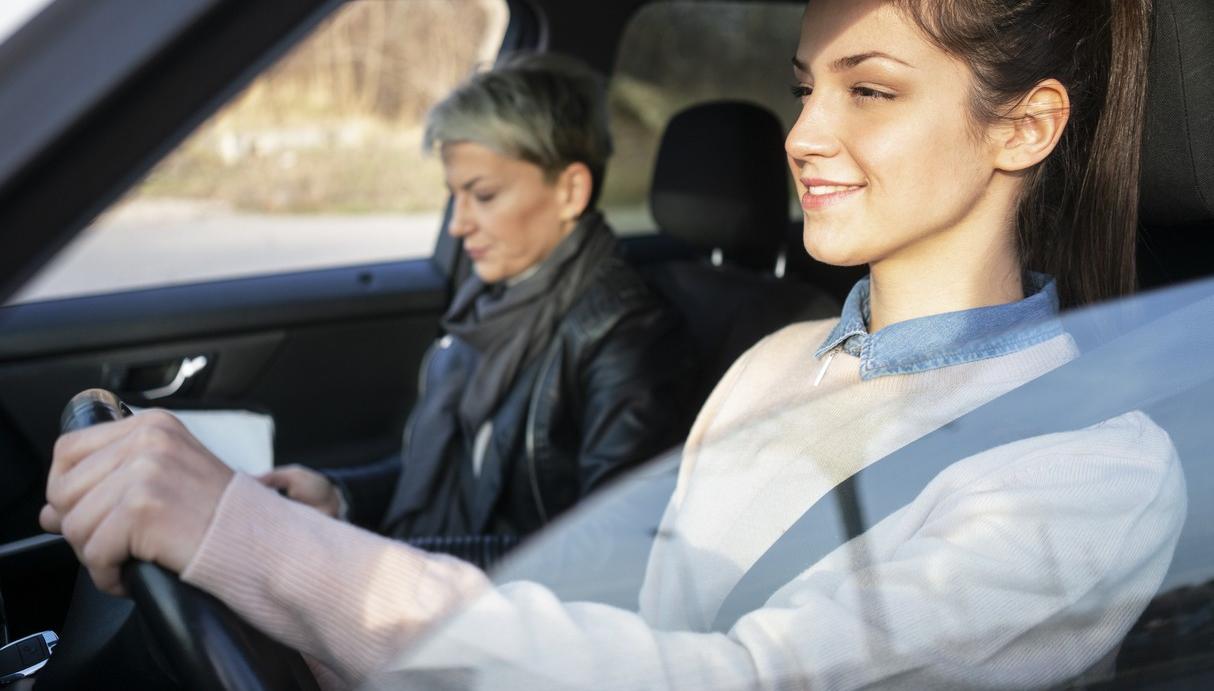 Ung kvinna övningskör med körskolelärare vid sidan av sig. foto.