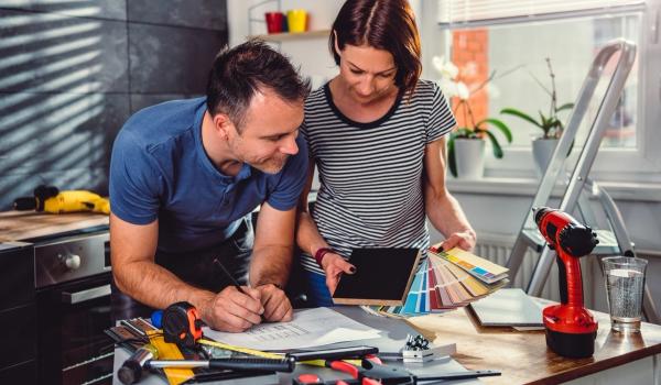 Man och kvinna ser över renoveringsplanerna och färgval. foto.