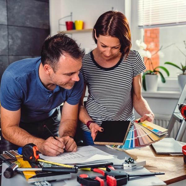 Man och kvinna ser över renoveringsplanerna och färgval. foto.
