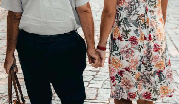 Äldre par håller händer