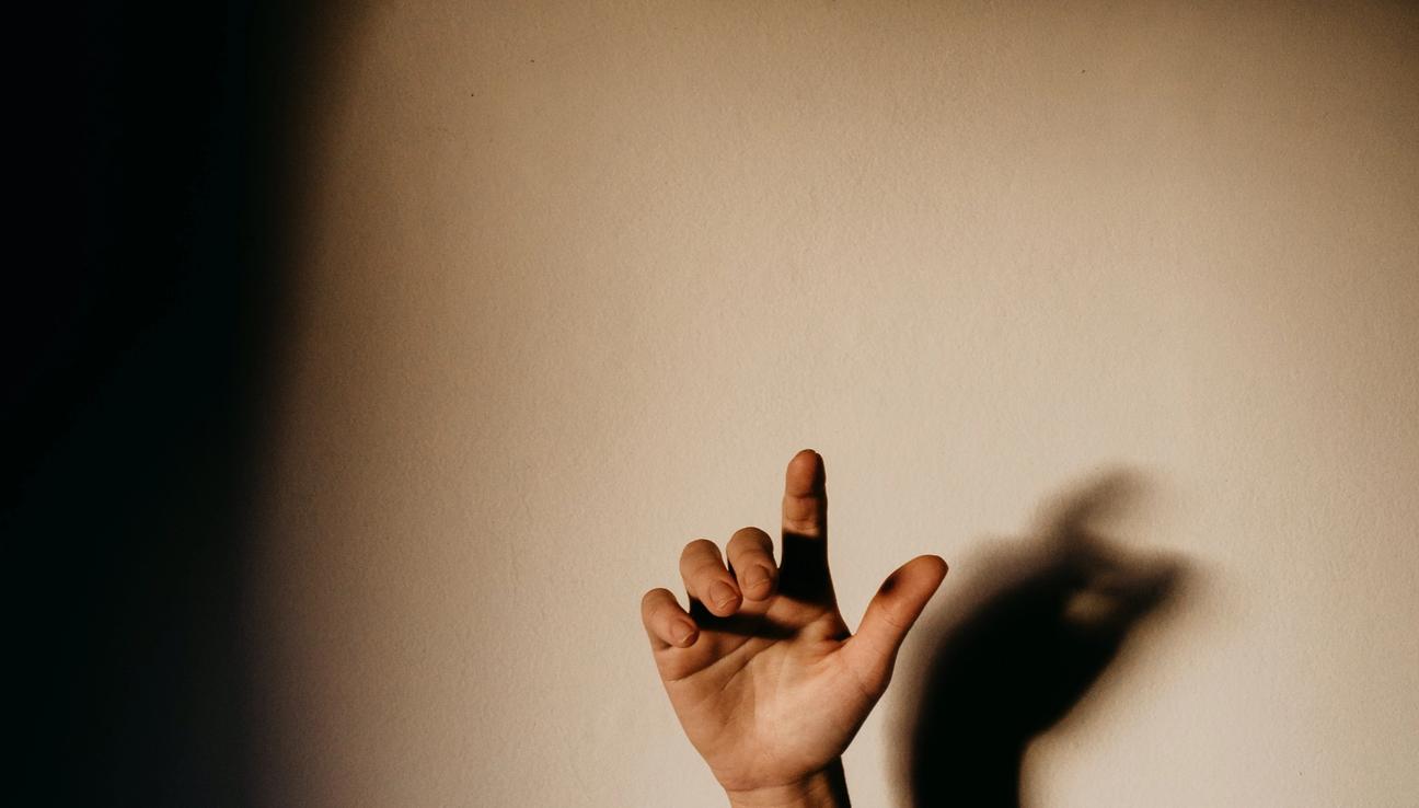 En hand och arm som gör skugga på väggen