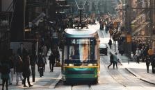 Raitiovaunu kulkee läpi ihmisjoukon Helsingissä