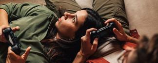Ett par ligger i soffan och spelar tv-spel