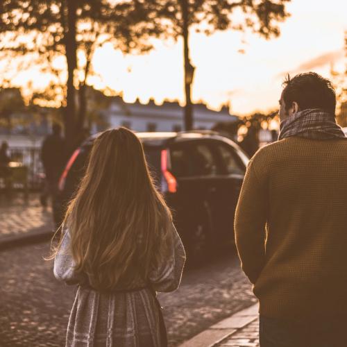 Ett par går vid sidan av varandra i staden