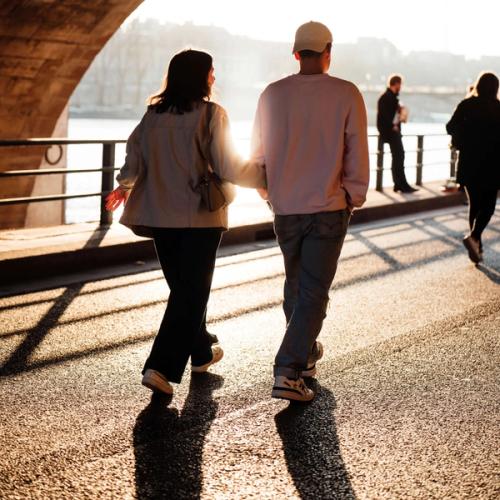 En kvinna och hennes son går arm i arm på kvällen