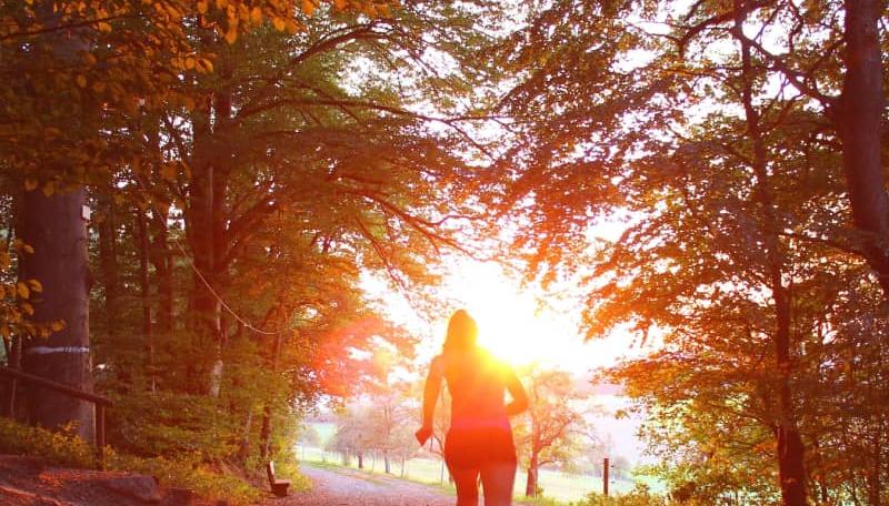 Kvinna springer i solnedgång