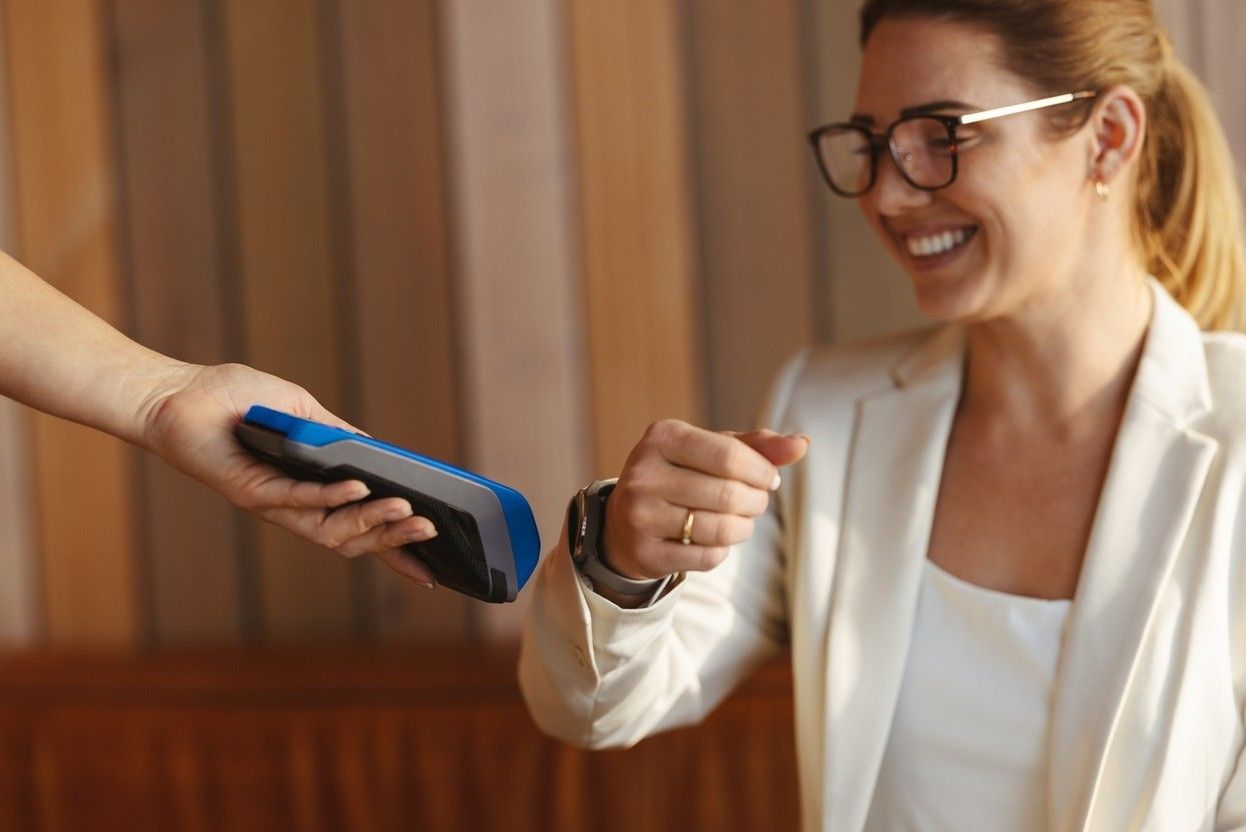 Kvinne betaler med digital betaling i klokken. bilde.