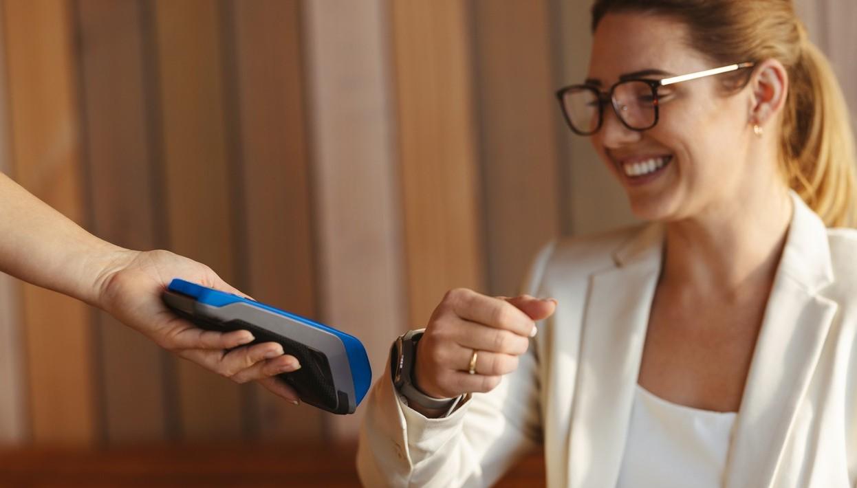 Kvinne betaler med klokken sin - enkelt og raskt. bilde.
