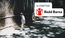 En pojk på vägen. Redd Barna logo som sier Vi stöttar Rädda barnen